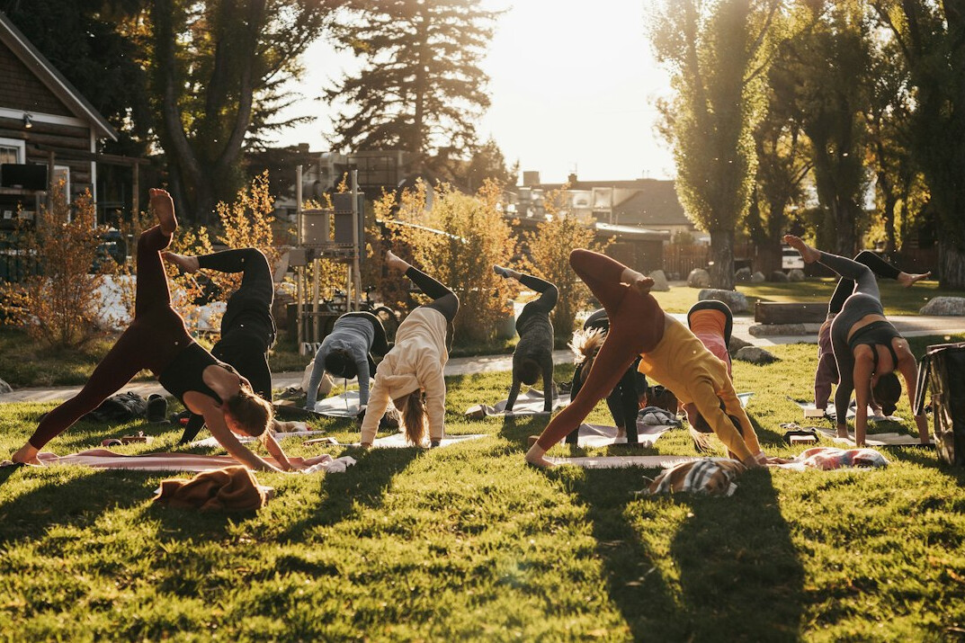Group of people practicing outdoor yoga and stretching exercises